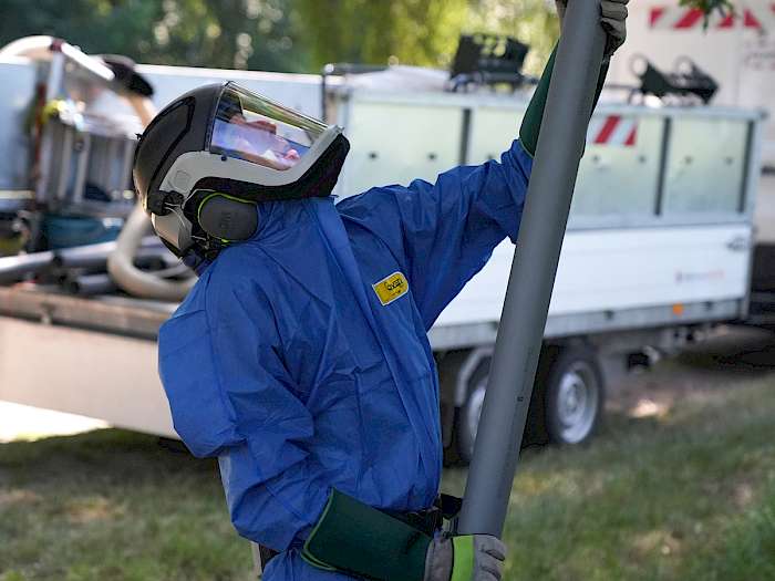 Kugler im Schutzanzug beim Absaugen