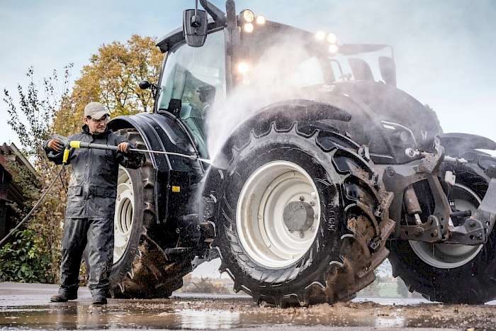 Traktor, der mit einem Hochdruckreiniger gereinigt wird