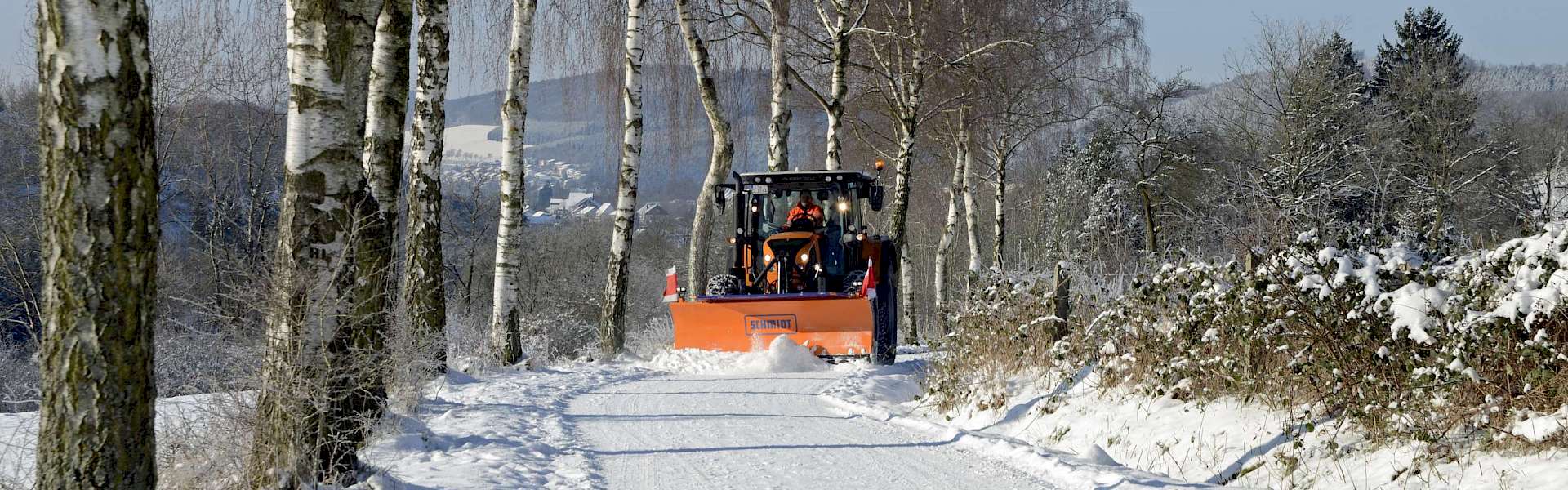 Kommunaler Winterdienst Kommunalschlepper mit Schneeschild
