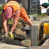Bauhofmitarebiter bei Straßensanierungsarbeiten im Hochsommer